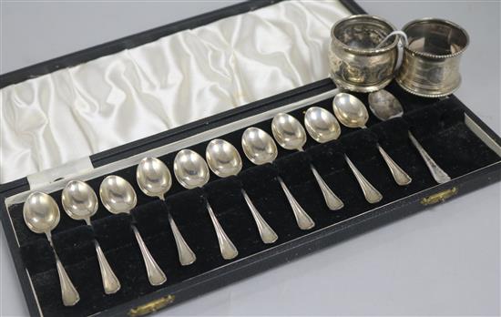 A cased set of eleven (ex 12) silver teaspoons and two silver napkin rings.